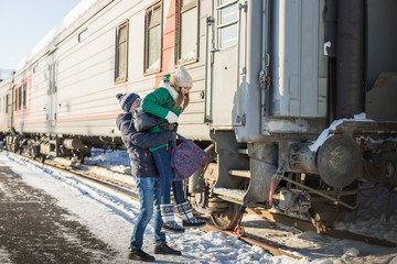 Couple at railway station near train in a winter time