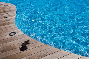 Piscine bleue avec plage en bois