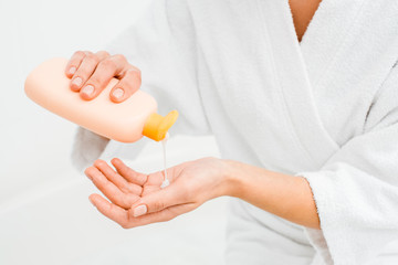 Close up of woman squeezing lotion in hand isolated on white