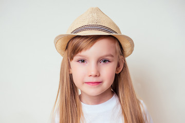 Summer portrait of a little blonde girl in a straw hat butterfly catching net on a white background in the studio.Pretty tourist traveling