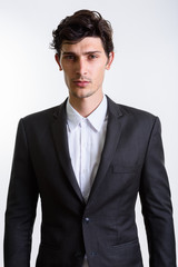 Studio shot of young handsome businessman looking at camera