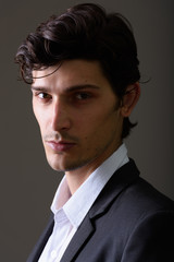 Studio shot of young handsome businessman looking at camera