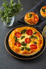 Vegetable pie with broccoli, tomatoes on the table close-up. Copy space.