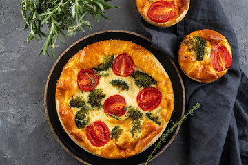 Vegetable pie with broccoli, tomatoes on the table close-up. Copy space.