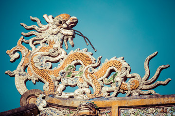Fototapeta na wymiar Detailed view of dragons on Citadel the Imperial City with the Purple Forbidden City in Hue, Vietnam.