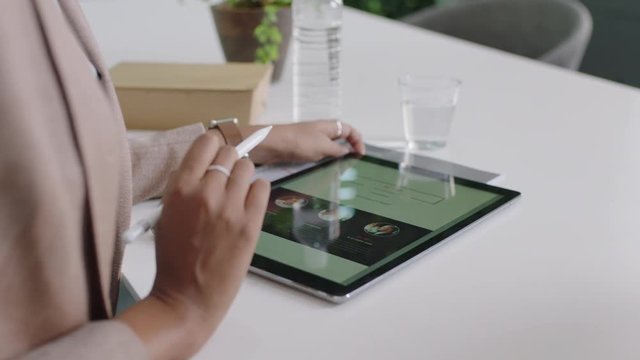 professional business woman using tablet computer presenting marketing strategy sharing ideas talking to client showing development plan on mobile technology in office meeting close up hands