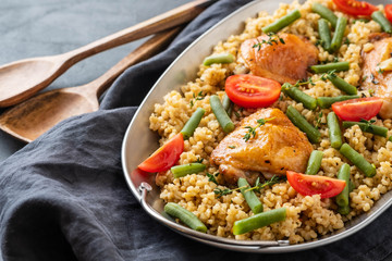 Grilled chicken thighs with bulgur, asparagus beans and tomatoes. Delicious lunch.