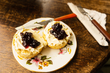 Traditional British scone with clotted cream and jam table setting