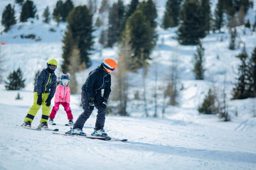 winter scene: a group of children are learning to ski