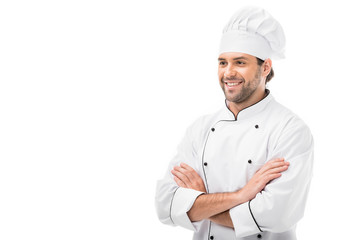 handsome young chef with crossed arms looking away isolated on white