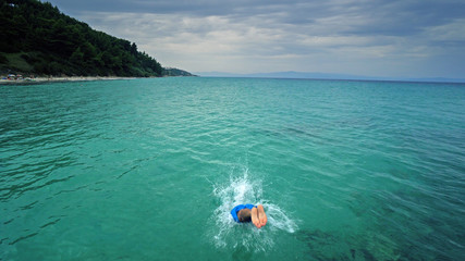 Attractive man jumping into water