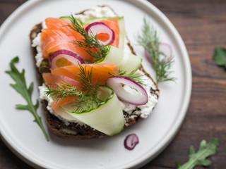 Traditional Danish  open sandwich - Smorrebrod .Dark rye bread with salmon slices and vegetables....
