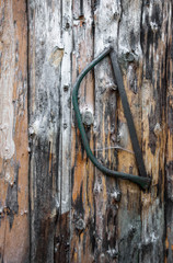old handsaw hanging on a wooden wall