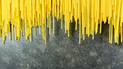 Yellow long spaghetti on a Rust stone background, Yellow italian pasta. Long spaghetti. Raw spaghetti bolognese, Food background concept, Blank for design..