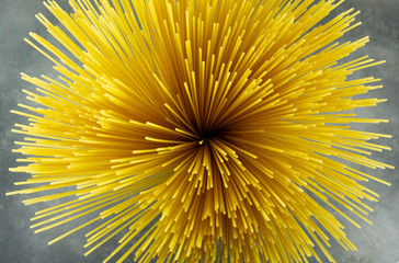 Yellow long spaghetti on black background. Thin pasta arranged in rows. Yellow italian pasta. Long spaghetti. Raw spaghetti wallpaper. Thin spaghetti. Food background concept.Top view.