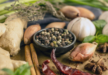 Spice collage - Mix of red, black and white pepper, garlic, shallots, spicy herbs, cinnamon, star anise, chili pepper, ginger, mint on a stone background