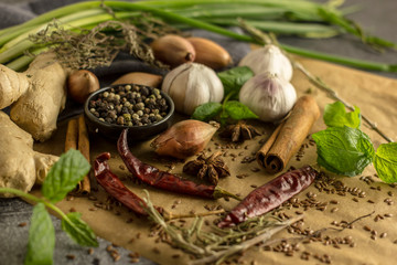 Spice collage - Mix of red, black and white pepper, garlic, shallots, spicy herbs, cinnamon, star anise, chili pepper, ginger, mint on a stone background
