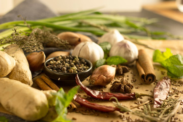 Spice collage - Mix of red, black and white pepper, garlic, shallots, spicy herbs, cinnamon, star anise, chili pepper, ginger, mint on a stone background