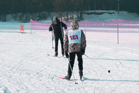 A boy in a red jacket with a sports number to ski the image of a Boy on the track in the Park.