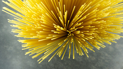 Yellow long spaghetti on a Rust stone background, Yellow italian pasta. Long spaghetti. Raw spaghetti bolognese, Food background concept, Blank for design..