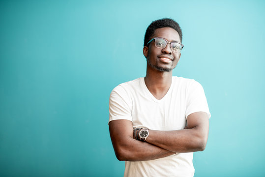 Portrait of a young african man dressed in white t-shirt standing on the colorful background