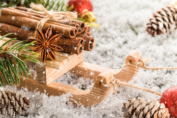     Christmas card with wooden sled with heap of cinnamon