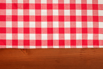 An overhead photo of a gingham cloth on a dark rustic wooden background, an abstract restaurant texture with a place for text