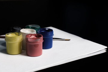 Multicolored cans of gouache with Paintbrush