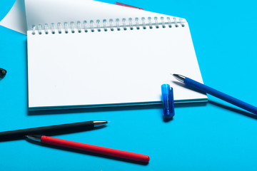 Top view workspace mockup on blue background with notebook, pen