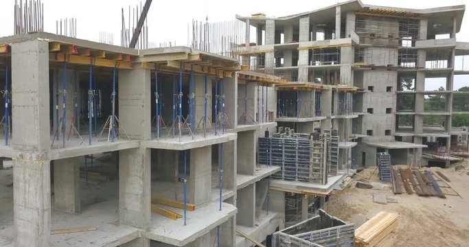 Flight above the construction site of the concrete frame of a multi-storey building. Concrete formwork and metal structures for building a house