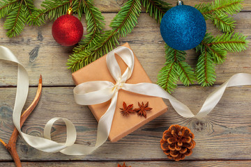 Christmas gift boxes and fir tree branch on wooden table.