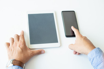 Closeup of business man using smartphone and tablet computer. Business man using digital devices. Technology and communication concept. Cropped view.