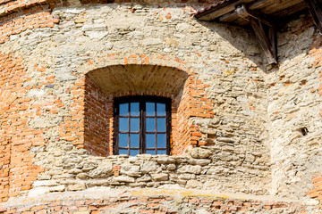 A small window in the thick wall of the medieval castle_
