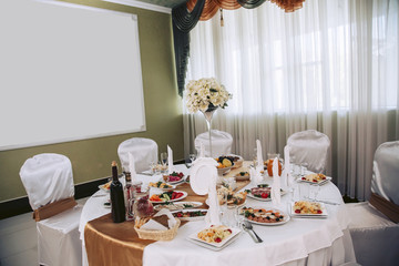 Festive table with food and drinks, covered with a white tablecloth with gold accents.