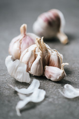 Close up view of ripe garlic bulbs and husk on grey surface