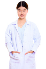 Studio shot of young beautiful Asian woman doctor standing with 