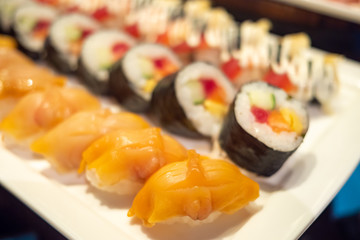 Selection of tasty and delicious Sushi. Most popular Japanese food. Nigiri Sushi is raw seafood on top of vinegared rice. Maki Sushi is rice wrapped in seaweed. Healthy eating and eat well concept.