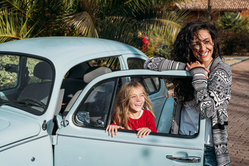 Mother with his daughter in the old car