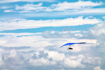 Fototapeta na wymiar Light aircraft, deltaplane, against the sky with white clouds. deltaplane
