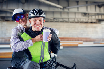 Photo of smiling sporty woman and man with bicycle on blurred background