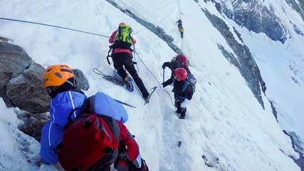 Photo sur Plexiglas Mont Blanc MONT BLANC, FRANCE - circa JUN, 2016: Mountaineers climb a snowy peak. In background the famous peak Dent du Geant in the Mont Blanc Massif, the highest european mountain. The Alps, Chamonix, France, Europ
