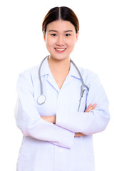 Studio shot of young happy Asian woman doctor smiling with arms 