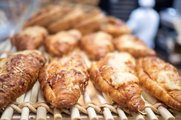 Assortment of delicious and buttery croissants decorated with cheese with fillings made by pastry chef. All look very tasty and delightful. Natural light.