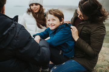 Happy family sitting by the beach