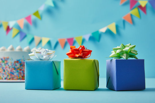 Three colorful  gifts on blue background with colorful bunting