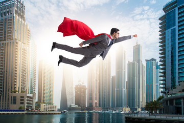 Superhero businessman flying over the city