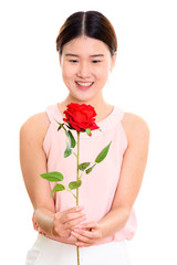 Studio shot of young happy Asian woman smiling and holding red r