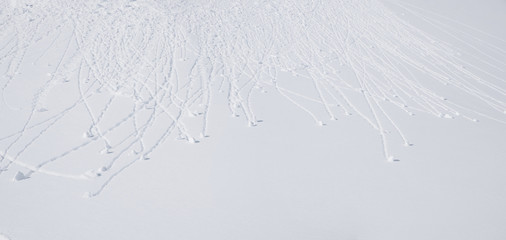 Schneedecke mit kullernden Schneebällen, winterlicher Hintergrund. Lawinengefahr.