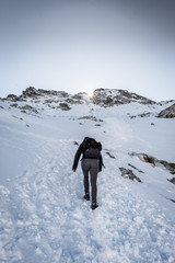 Wanderer in den Bergen im Schnee beim Aufstieg