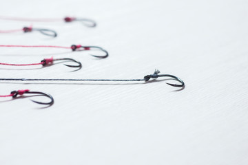 Many of the fishing hook Placed on a white wooden floor with emp